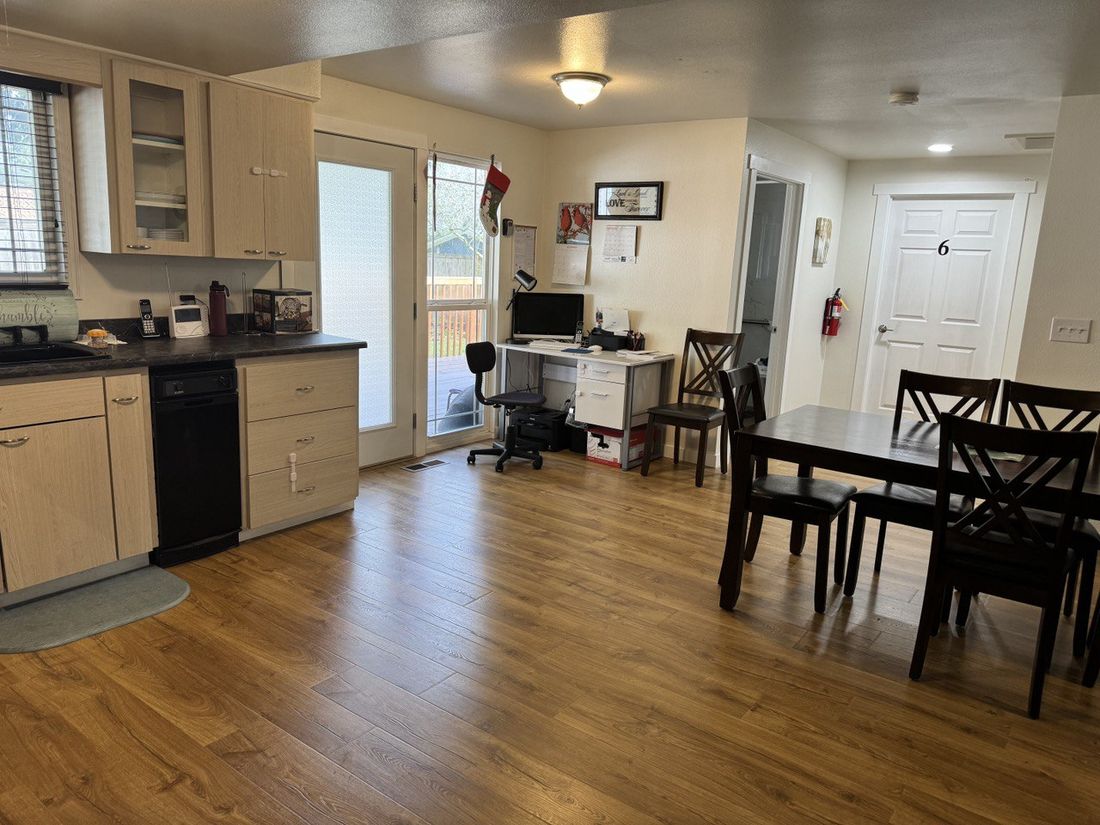 Comfortable dining and common area with a sunlit doorway leading to the backyard deck
